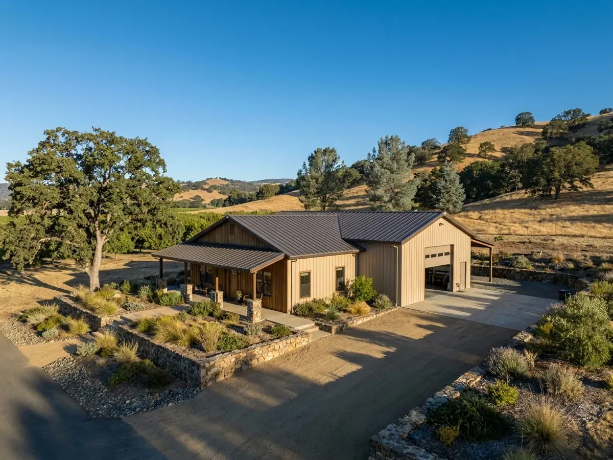 A completed barndominium home viewed from the front corner, with drought-tolerant landscaping, a covered entry porch and an attached shop bay.